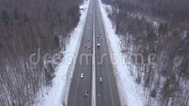 在冬季公路上行驶的汽车和卡车通过白雪森林的鸟瞰图